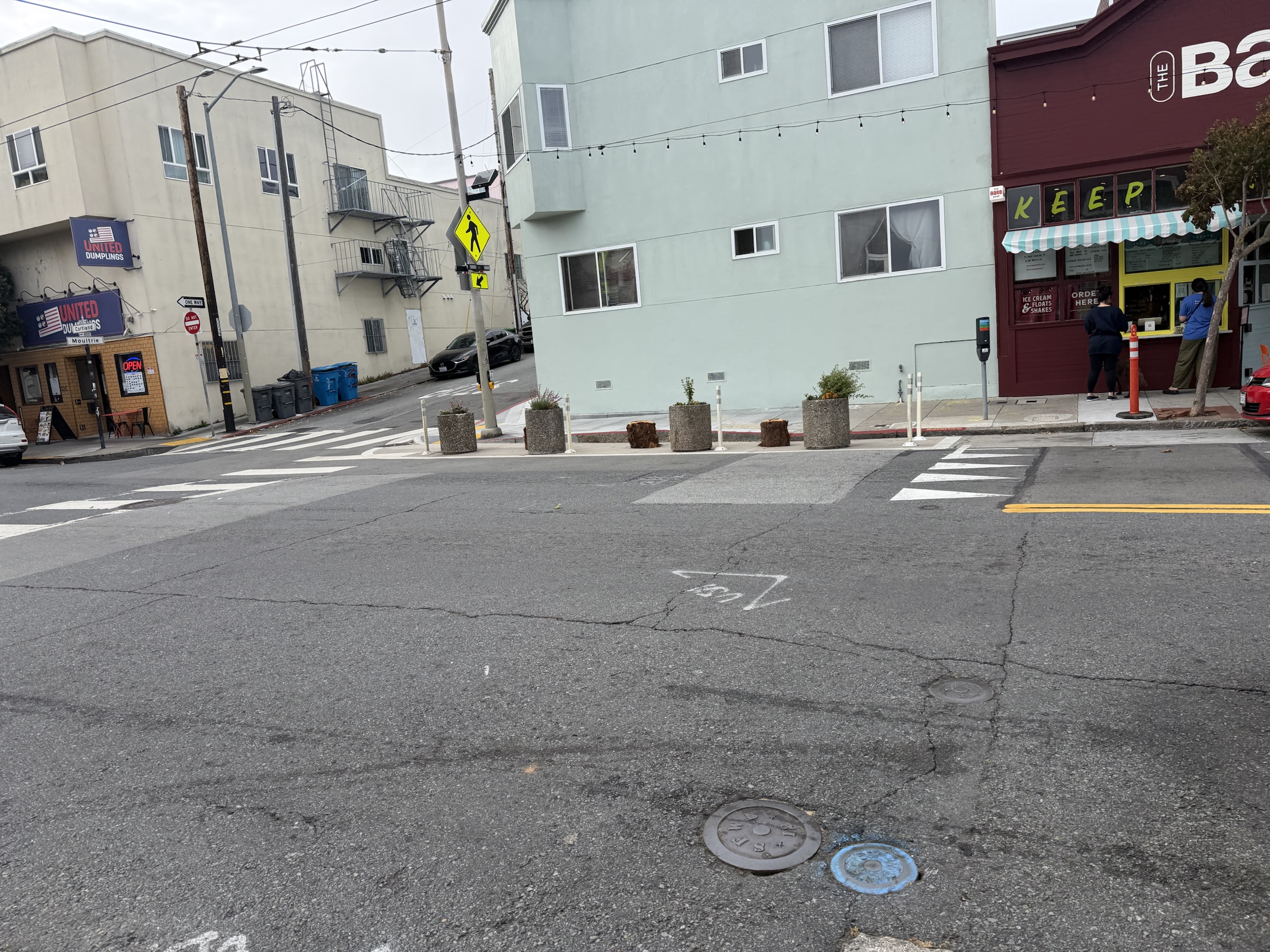 Planters and soft posts protecting a Community Corner on Cortland Avenue
